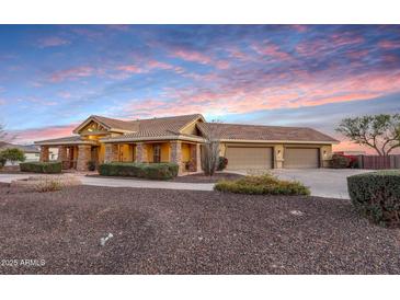 Lovely home featuring a long driveway, three car garage, and desert landscaping at 18919 W Verde Ln, Litchfield Park, AZ 85340