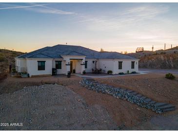 Stunning exterior of a modern desert home with landscaped front, tile roof and rock features in natural desert environment at 4289 W Caribou Ln, Queen Creek, AZ 85142