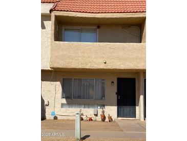 Townhouse exterior with stucco facade, balcony, and tiled roof, creating a warm and inviting curb appeal at 4845 W Marlette Ave, Glendale, AZ 85301