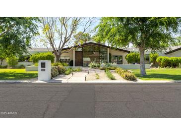 Beautifully landscaped front yard and modern home exterior with large windows at 6301 E Exeter Blvd, Scottsdale, AZ 85251