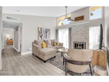 Bright living room features a modern fireplace, neutral decor, and wood-look tile floors at 930 S Dobson Rd # 41, Mesa, AZ 85202