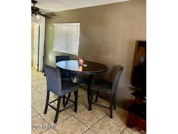 A cozy dining area features a table with seating for three and bright natural light from a window at 1621 N 38Th Dr, Phoenix, AZ 85009