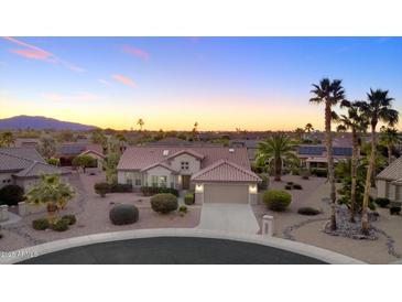 Stunning single-Gathering home with desert landscaping, tile roof, and attached two-car garage at sunset at 16464 W Una Noche Ct, Surprise, AZ 85374