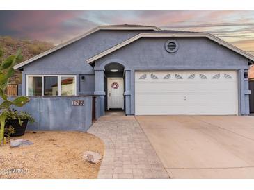 Charming single-story home featuring a well-manicured yard, a two-car garage, and desert landscaping at 1723 E Behrend Dr, Phoenix, AZ 85024