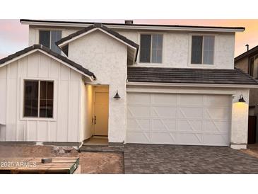 Charming two-story home with a white exterior, a two-car garage, and a welcoming front entrance at 18243 W Larkspur Dr, Goodyear, AZ 85338