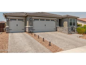 Charming home features a three car garage, complemented by a well-maintained, grey brick driveway at 19806 W San Miguel Ave, Litchfield Park, AZ 85340