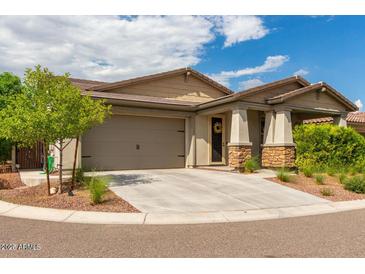 Charming single-Gathering home with neutral stucco and stone accents, attached garage, and landscaped front yard at 19982 W Glenrosa Ave, Litchfield Park, AZ 85340