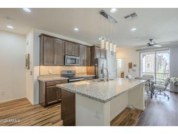 Spacious kitchen boasts granite countertops, stainless appliances, and an island at 2673 S Balsam Dr, Gilbert, AZ 85295