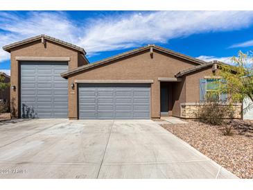 Charming single-story home featuring a gray garage door, desert landscaping, and a concrete driveway at 4642 W Suncup Dr, San Tan Valley, AZ 85144