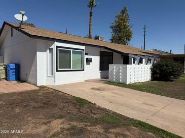 Charming single-story home with a clean, white exterior and well-maintained front yard at 5000 W Osborn Rd, Phoenix, AZ 85031