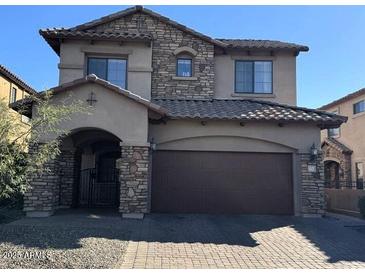 Charming two-story home featuring stone accents, a tile roof, and a two-car garage at 7253 E Nathan St, Mesa, AZ 85207