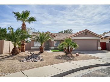 Single-story house with a two-car garage, low-maintenance landscaping, and mature palm trees in the front yard at 7259 W Tina Ln, Glendale, AZ 85310