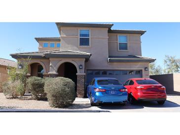 Two-story home featuring stacked stone accents, a two-car garage, and a tile roof at 8420 S 40Th Dr, Laveen, AZ 85339