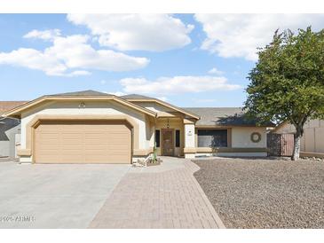 Charming single-story home featuring a two-car garage and a well-manicured front yard, with desert landscaping at 8562 W Windsor Blvd, Glendale, AZ 85305