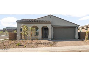 Charming single-story home featuring a stylish arched entryway and a convenient two-car garage at 13548 W Copperleaf Ln, Peoria, AZ 85383