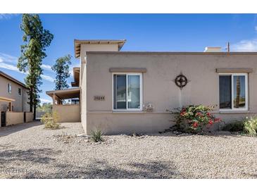 Tan home exterior featuring desert landscaping, two windows, and a decorative metal accent under a clear, blue sky at 14644 N Yerba Buena Way # C, Fountain Hills, AZ 85268