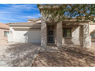 Charming single-Gathering home featuring a two-car garage and covered front porch, surrounded by desert landscaping at 17254 W Marshall Ln, Surprise, AZ 85388
