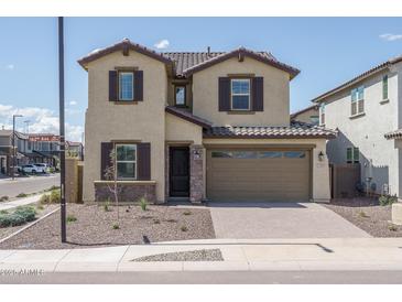 Charming two-story home with brown tiled roof, desert landscaping, and a two-car garage at 23764 N 162Nd Ave, Surprise, AZ 85387