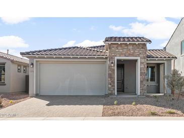 Charming single-story home featuring a stone facade, desert landscaping, and a spacious two-car garage at 32076 N 136Th Ave, Peoria, AZ 85383