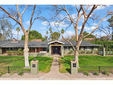 Charming single-story home with lush landscaping, mature trees, and a brick pathway leading to the front door at 620 W Mclellan Blvd, Phoenix, AZ 85013