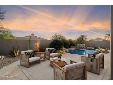 Relaxing backyard with a private pool, waterfall feature, and outdoor seating for entertaining at 7111 E Sienna Bouquet Pl, Scottsdale, AZ 85266