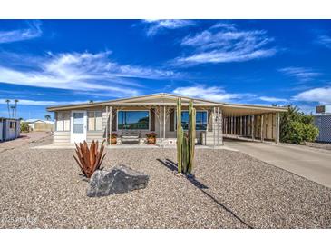 Charming home with low maintenance desert landscaping, covered parking, and ample curb appeal at 7408 E Bosaga Way, Mesa, AZ 85208