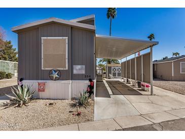 Charming mobile home exterior with covered parking and desert landscaping at 201 S Greenfield Rd # 254, Mesa, AZ 85206