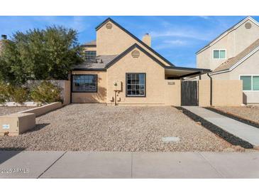 Charming single-story home featuring a well-maintained exterior with black trim windows, complemented by a low maintenance yard at 2138 W Beaubien Dr, Phoenix, AZ 85027