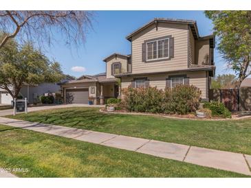 Charming two-story home featuring desert landscaping, a well-manicured lawn, and a two-car garage in a tranquil neighborhood at 3062 E Cullumber St, Gilbert, AZ 85234