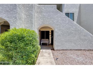 Inviting entrance features an arched doorway and a bench for relaxing outdoors at 4730 W Northern Ave # 1102, Glendale, AZ 85301