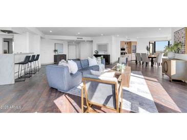 Bright, open living space with wood floors, modern furnishings, city views, and a seamless flow to dining and kitchen at 1040 E Osborn Rd # 1004, Phoenix, AZ 85014
