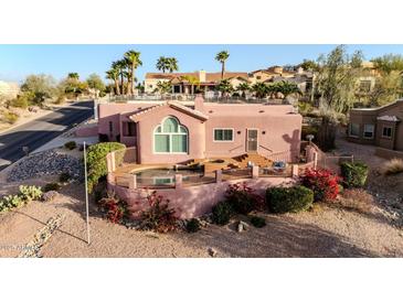 Charming home with a backyard pool and deck area surrounded by beautiful desert landscaping at 15865 E Lost Hills Dr, Fountain Hills, AZ 85268