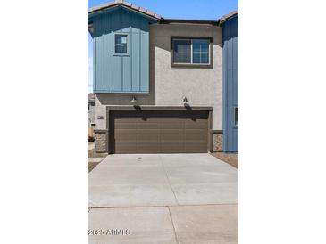 View of a two-story home with a brown garage door and driveway at 7446 S 75Th Dr, Laveen, AZ 85339