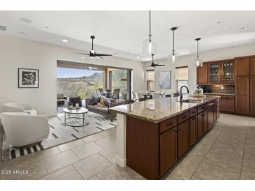 Bright, open-concept kitchen with granite countertops, wood cabinets, and seamless access to outdoor living space at 27000 N Alma School Pkwy # 1024, Scottsdale, AZ 85262