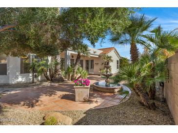 Serene backyard oasis featuring mature trees, a decorative fountain, and a cozy patio area at 721 W Cherrywood Dr, Chandler, AZ 85248