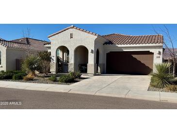 Inviting single-story stucco home with a tile roof, arched entryway, and a two-car garage at 12330 E Crystal Frst, Gold Canyon, AZ 85118