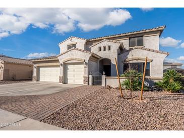 Inviting home featuring a three-car garage, beautiful landscaping, and a private gated entrance at 16918 W Statler St, Surprise, AZ 85388