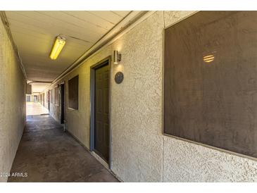 Building exterior shows unit door with security screen and stucco detail at 18202 N Cave Creek Rd # 134, Phoenix, AZ 85032