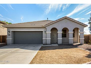 Charming single-story home featuring an attached garage, neutral colors and a well-manicured front yard at 21333 N Denton Dr, Maricopa, AZ 85138