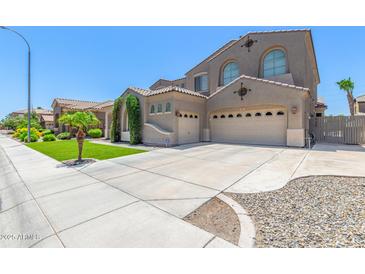 Attractive home featuring a three car garage, neutral color palette, and well manicured lawn at 2453 E Ebony Dr, Chandler, AZ 85286