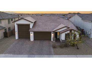 Charming single-story home showcasing a three-car garage, and a meticulously paved driveway at 25658 N 140Th Ln, Surprise, AZ 85387