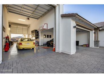 Three car garage showcasing epoxy floors, storage space, and a modern design at 25658 N 140Th Ln, Surprise, AZ 85387