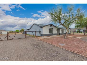 Charming gray single story home with stone accents, mature trees, and gravel driveway at 25723 S Hawes Rd, Queen Creek, AZ 85142