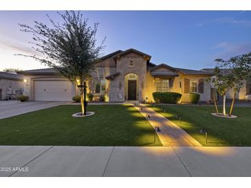 Charming home featuring a manicured lawn, desert landscaping and illuminated walkway at 2882 E Wildhorse E Dr, Gilbert, AZ 85297