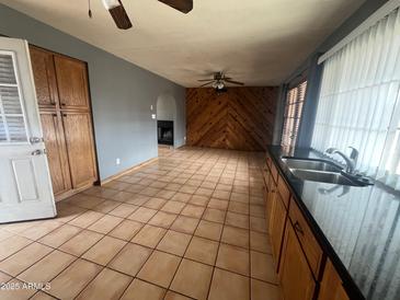 An expansive living area featuring wood paneling, tile floors, and abundant natural light at 4537 E Hidalgo Ave, Phoenix, AZ 85040