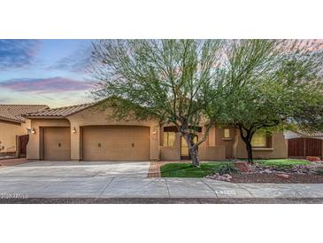 Charming home featuring a three car garage, desert landscaping, and a cozy front porch at 5523 W Yearling Rd, Phoenix, AZ 85083