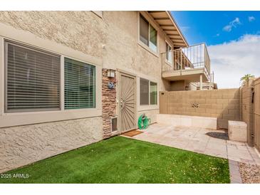 Cozy backyard with artificial turf, block wall, and hardscaped patio, perfect for outdoor living at 8532 E Belleview St, Scottsdale, AZ 85257