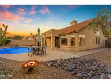 Inviting backyard featuring a pool, fire pit, and outdoor dining area at sunset at 1229 E Glenhaven Dr, Phoenix, AZ 85048