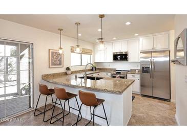 Bright kitchen with stainless steel appliances, granite counters and island with bar stool seating at 1293 E Clifton Ave, Gilbert, AZ 85295