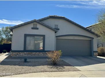 Charming single-story home featuring a two-car garage, neutral stucco exterior, and low maintenance desert landscaping at 16535 W Fillmore St, Goodyear, AZ 85338